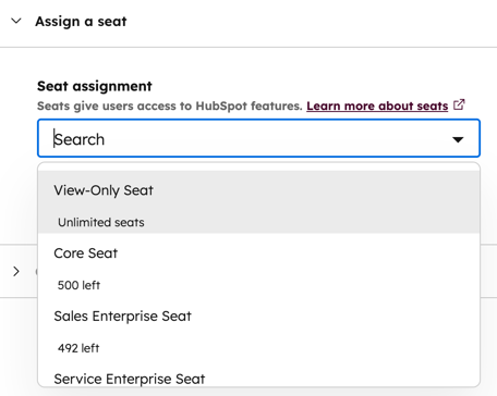 A dropdown menu in HubSpot for assigning a seat to a new user, with various seat types listed.